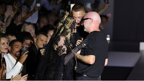 Milano Fashion Week, Dolce&Gabbana l'abbraccio con Madonna in prima fila con velo in pizzo nero, alla fine dello show